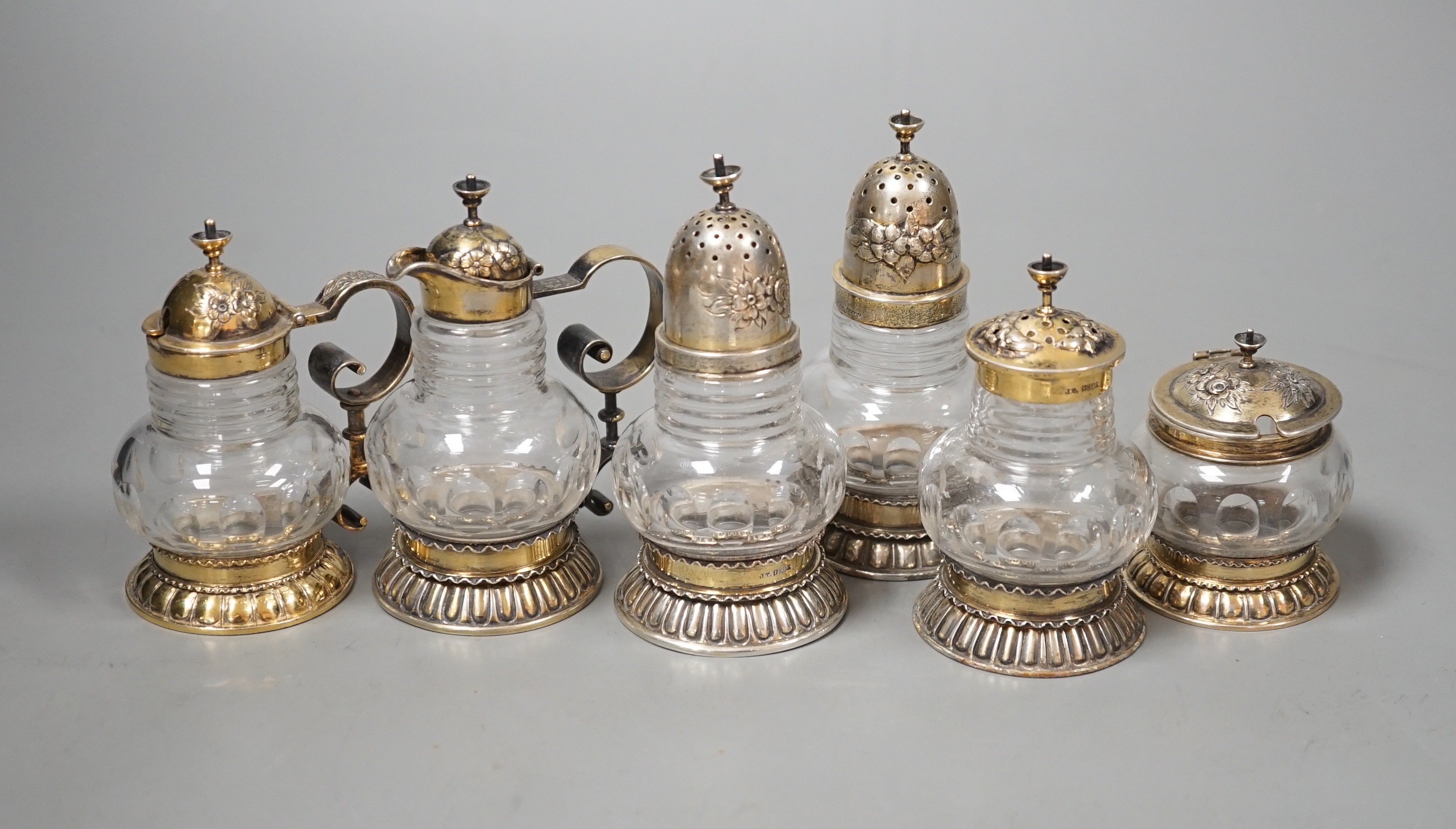 A late 19th/early 20th century Norwegian 830 standard gilt white metal mounted glass six piece cruet set, possibly by J. Tostrup, two pieces unmarked, tallest 97mm.